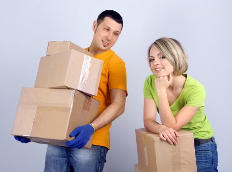 Professional movers carrying furniture from a flat in East London